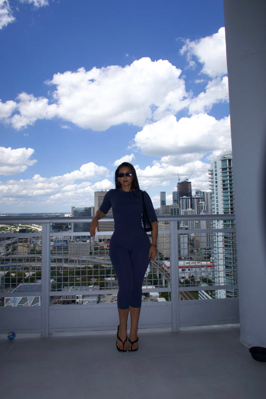 Navy CAPRI SET, fitted short-sleeve top and high-waisted capri leggings, front view, on a rooftop