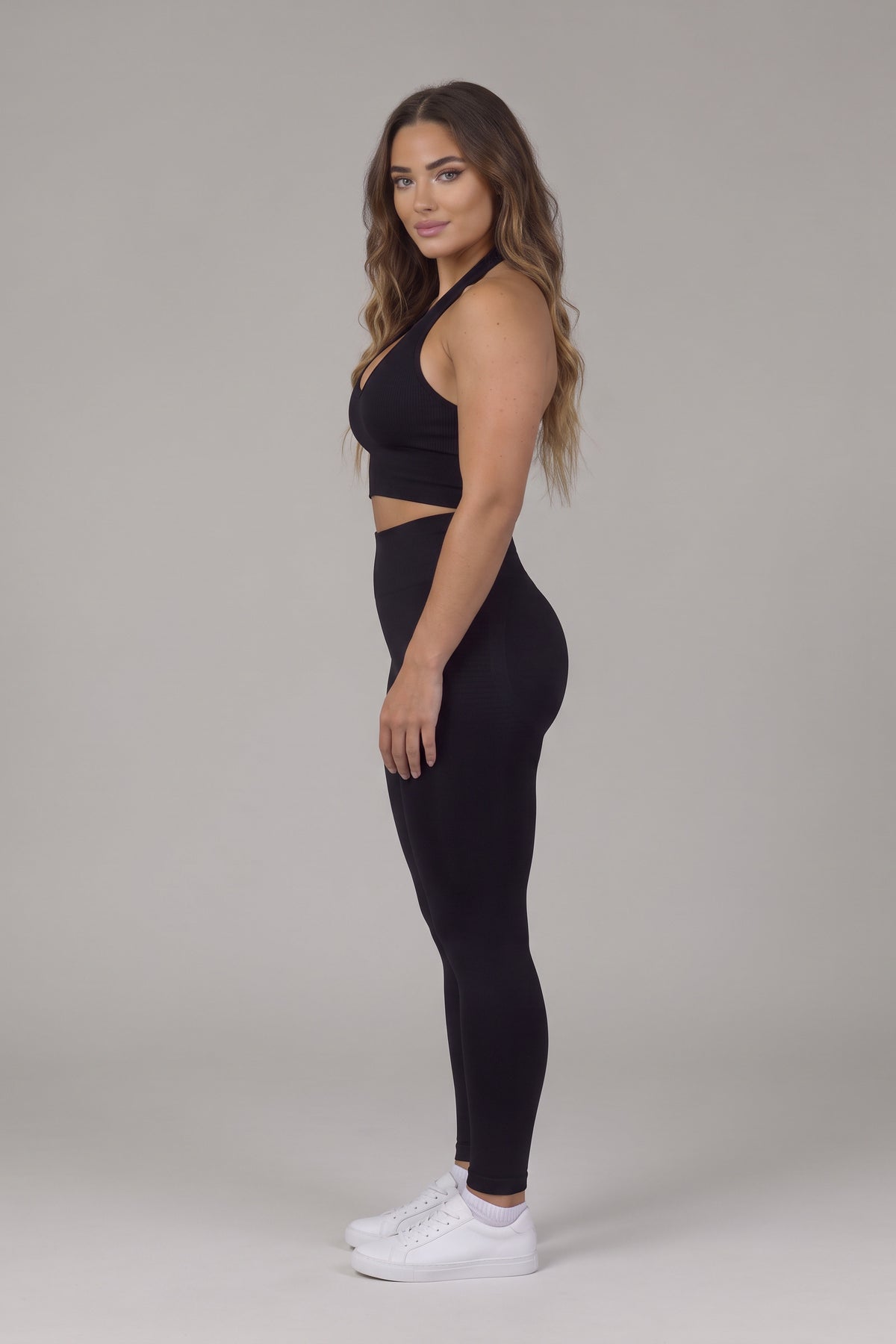 Side view of the black CAROLINA SET halter top and high-waist leggings