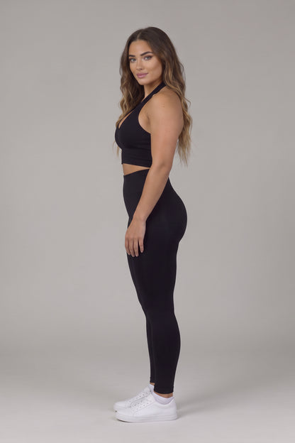 Side view of the black CAROLINA SET halter top and high-waist leggings