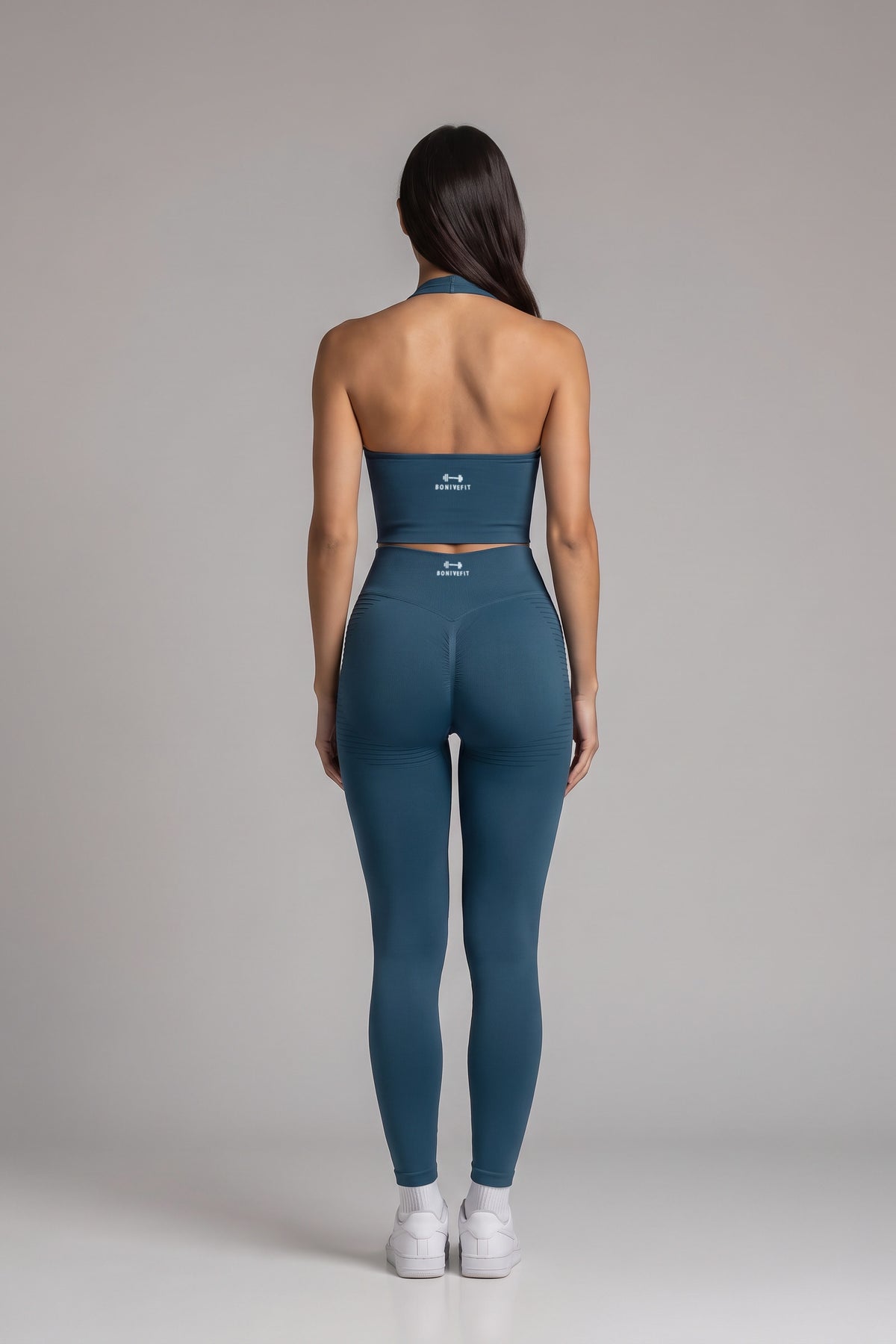 Back view of the turquoise CAROLINA SET open-back halter top and scrunch leggings with Bonive Fit logo