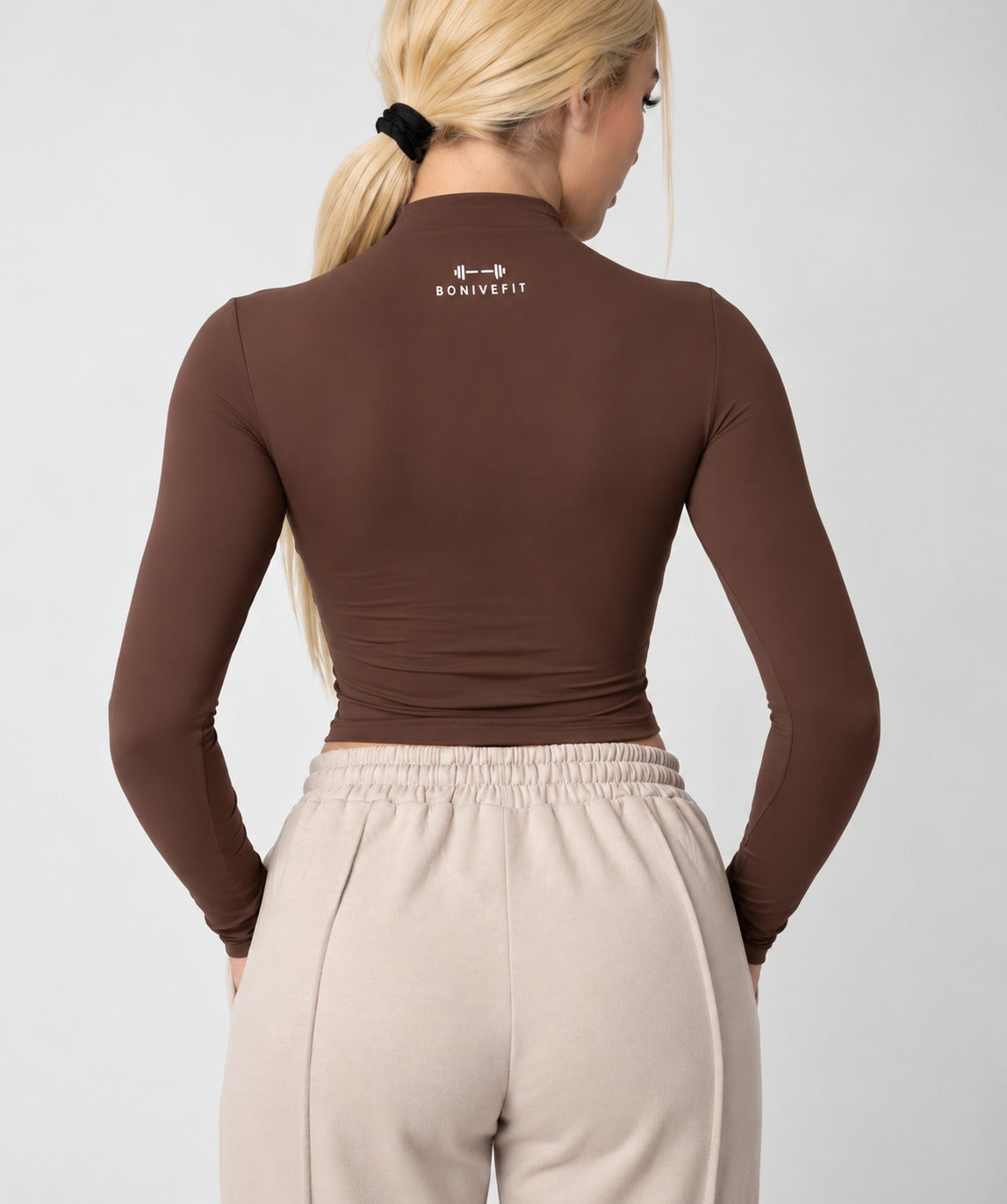 Brown DURA TOP, long-sleeve mock-neck crop top, back view, logo at the back of the neck