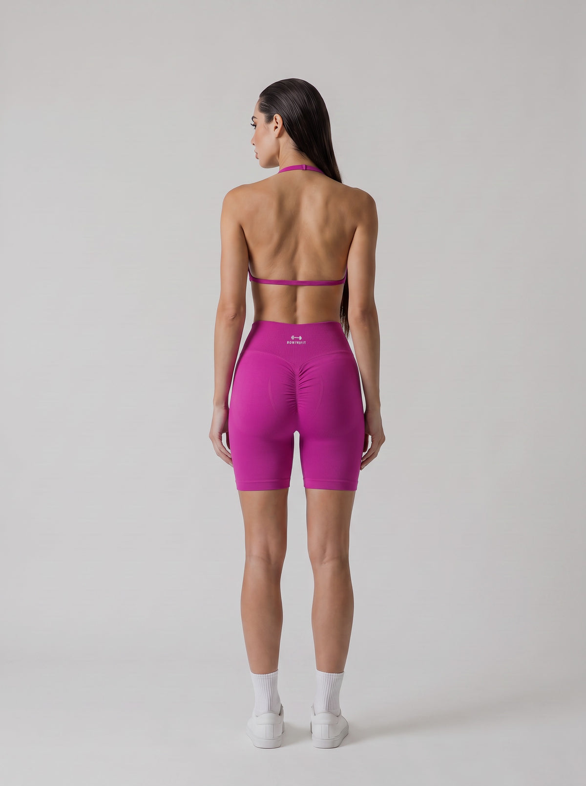 MIAMI VIBES SET fucsia, top halter y short de tiro alto, vista de espalda, espalda abierta y logo en el short