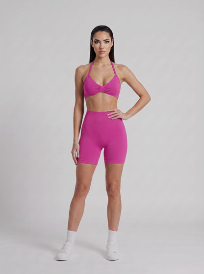 MIAMI VIBES SET fucsia, top halter y short de tiro alto, de frente, una mano en la cintura