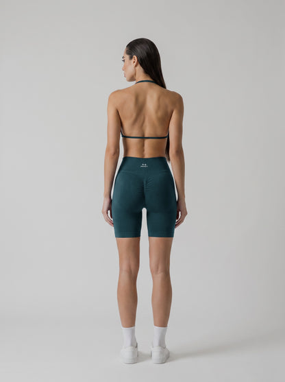 MIAMI VIBES SET verde esmeralda, top halter y short de tiro alto, vista de espalda, espalda abierta y logo en el short