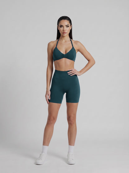 MIAMI VIBES SET verde esmeralda, top halter y short de tiro alto, de frente, una mano en la cintura