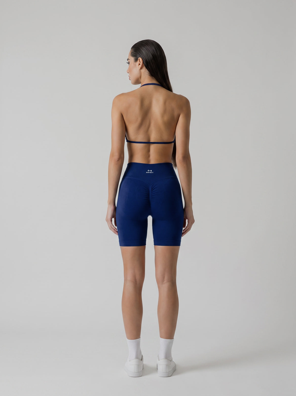 MIAMI VIBES SET azul marino, top halter y short de tiro alto, vista de espalda, espalda abierta y logo en el short