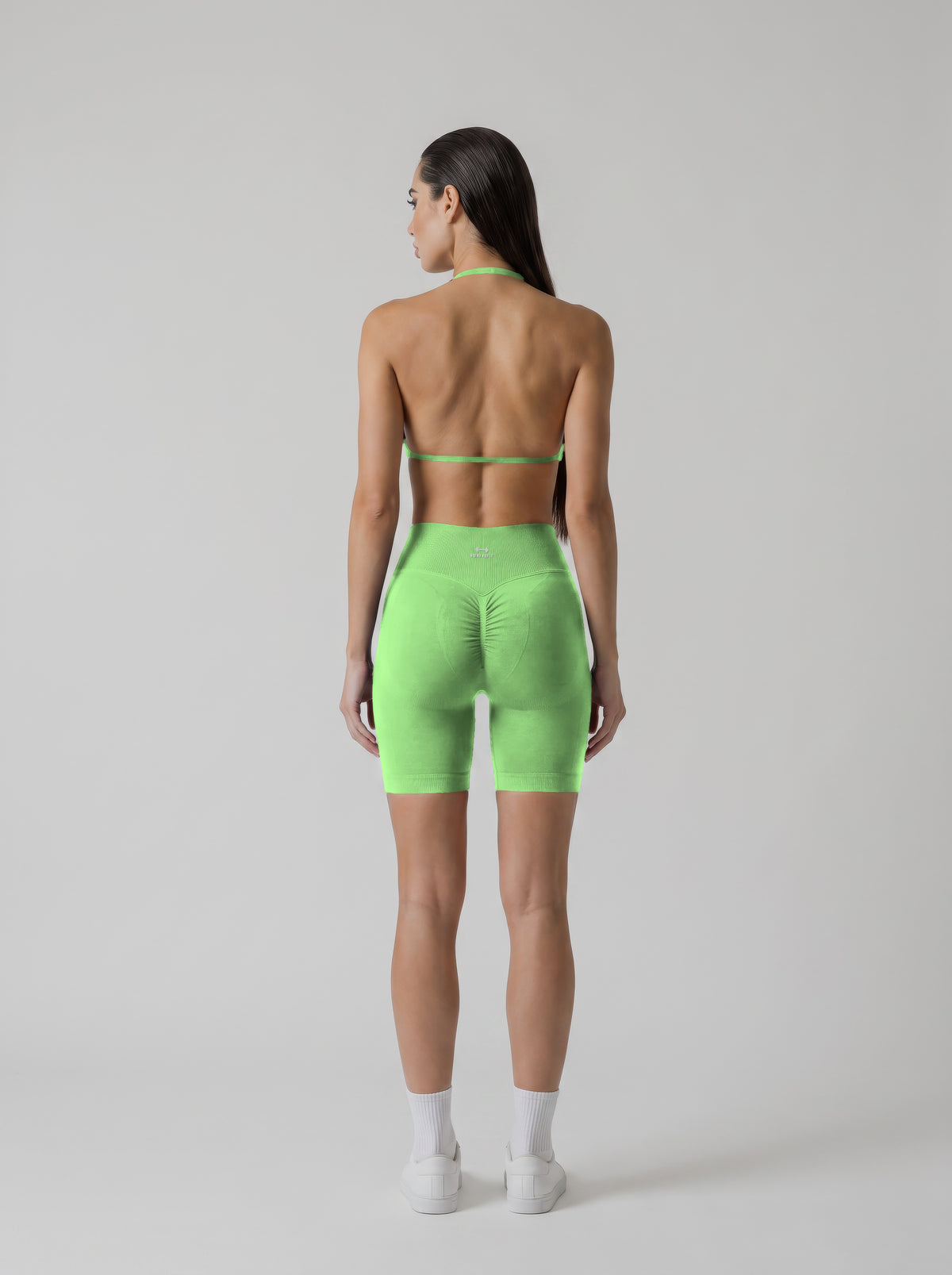 MIAMI VIBES SET verde neón, top halter y short de tiro alto, vista de espalda, espalda abierta y logo en el short