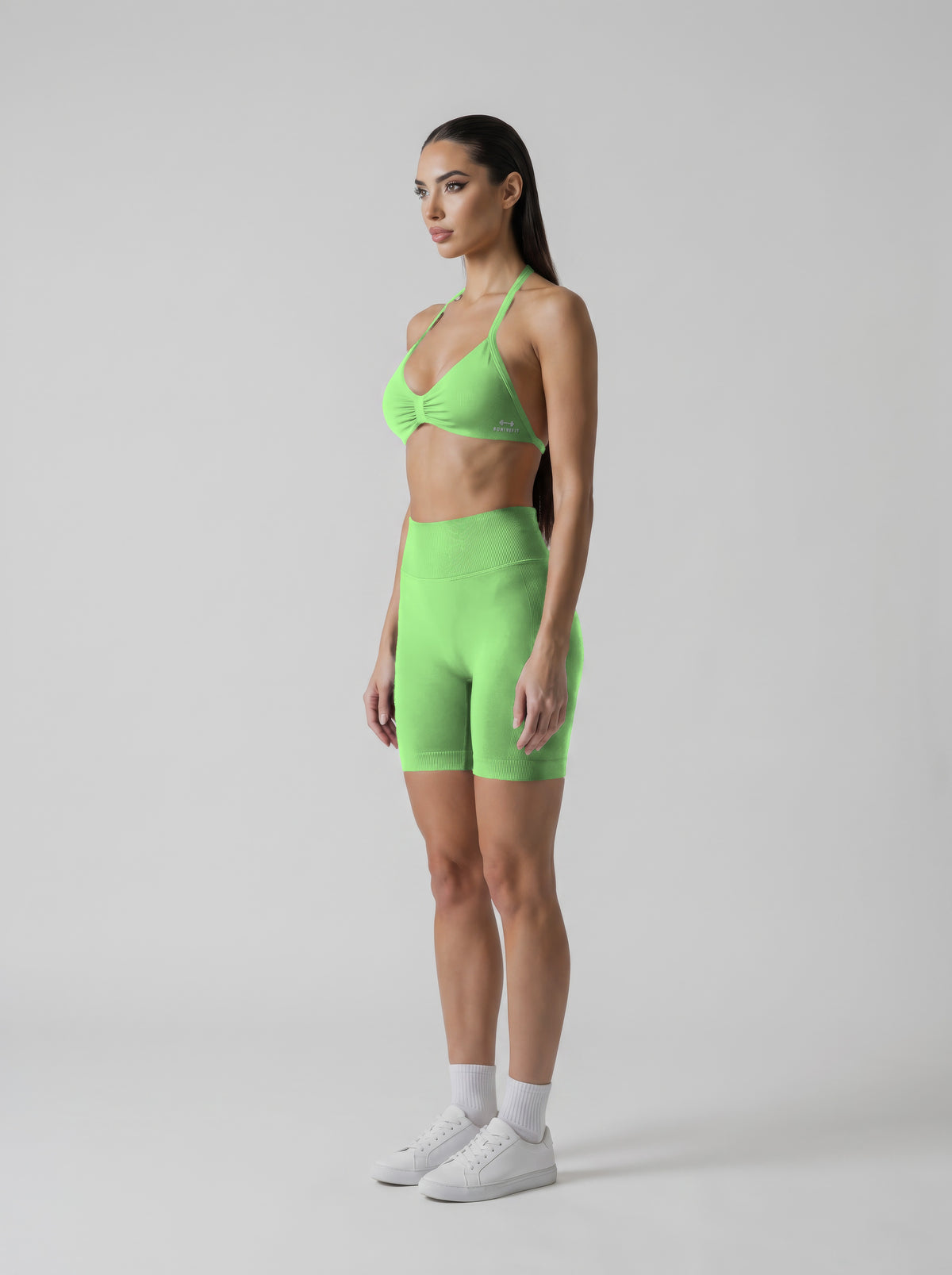 MIAMI VIBES SET verde neón, top halter y short de tiro alto, vista de tres cuartos izquierda, logo en el top