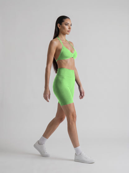 MIAMI VIBES SET verde neón, top halter y short de tiro alto, tres cuartos derecha, caminando