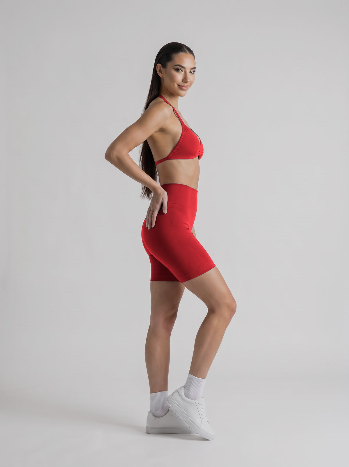MIAMI VIBES SET rojo vibrante, top halter y short de tiro alto, de perfil, una mano en la cintura