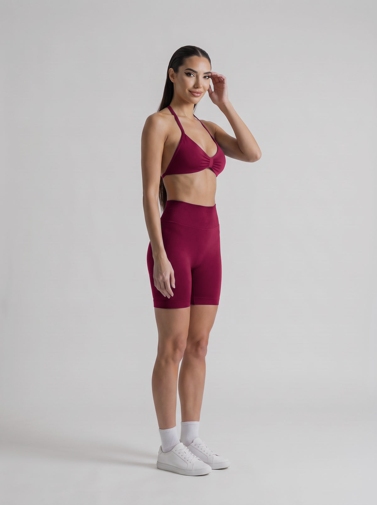 MIAMI VIBES SET Winter Berry, top halter y short de tiro alto, tres cuartos derecha, una mano en el pelo
